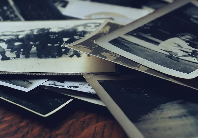 Old black and white family photos scattered on a table